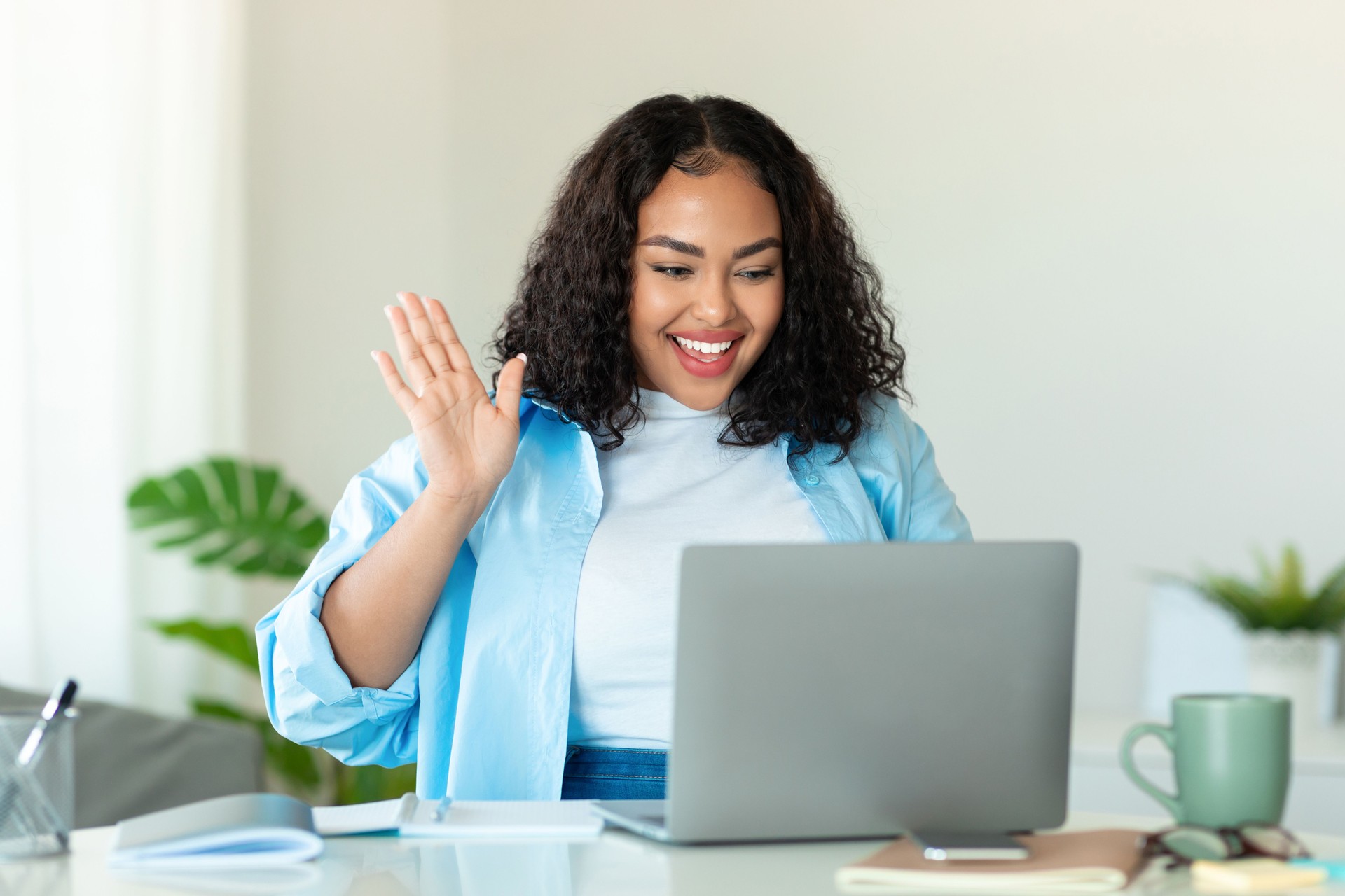 Online meeting concept. Happy black body positive lady using laptop for virtual conferencing, having video call at home